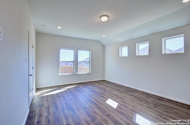 unfurnished room with dark hardwood / wood-style flooring and lofted ceiling