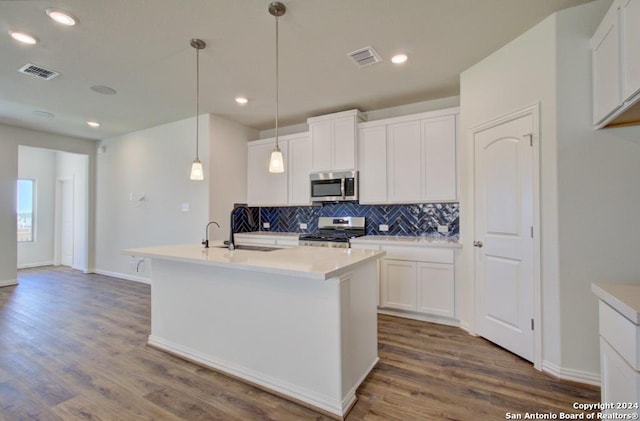 kitchen with appliances with stainless steel finishes, a kitchen island with sink, white cabinetry, and sink