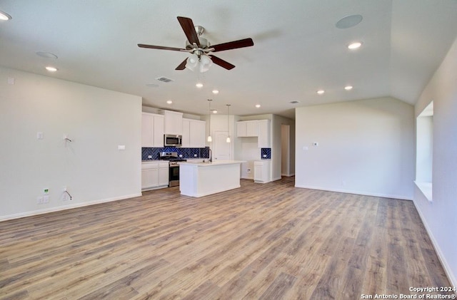 unfurnished living room featuring light hardwood / wood-style floors, sink, lofted ceiling, and ceiling fan