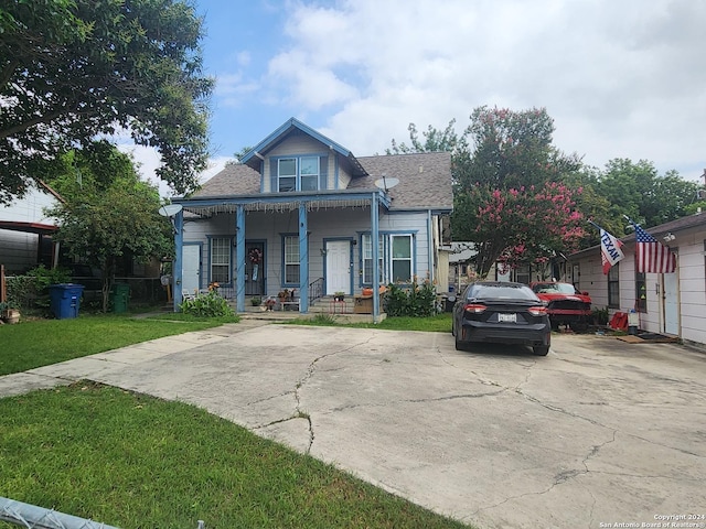 bungalow-style home with covered porch and a front lawn