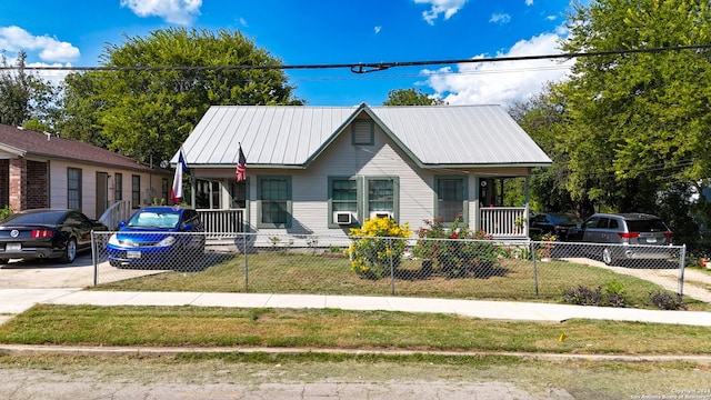 bungalow with a front yard, cooling unit, and a porch