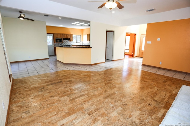 unfurnished living room with light tile patterned floors and ceiling fan