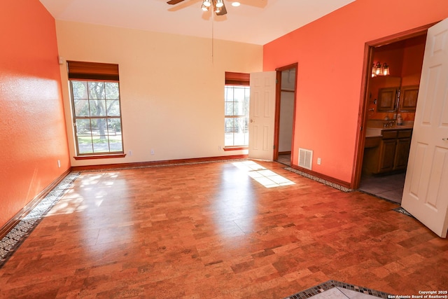 unfurnished room with ceiling fan and a healthy amount of sunlight