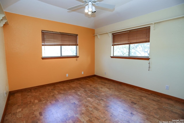 empty room with ceiling fan, a healthy amount of sunlight, and wood-type flooring