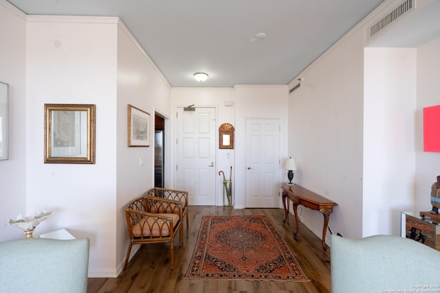 entrance foyer featuring wood-type flooring and crown molding