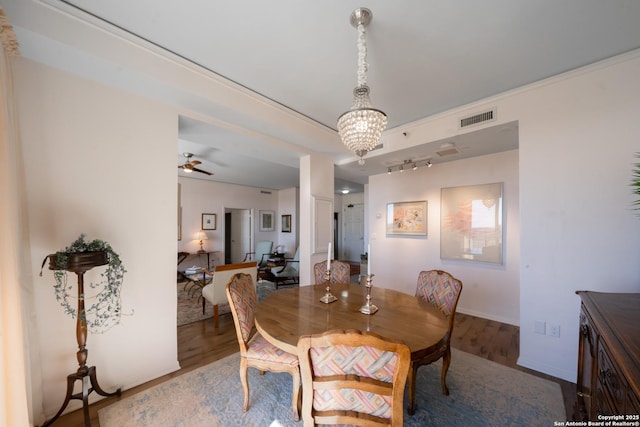 dining space featuring ceiling fan with notable chandelier and hardwood / wood-style floors