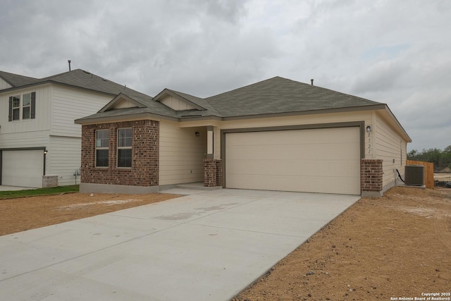 8321 Roadrunner Psge, San Antonio, TX 78222 - view of front of property featuring driveway, a garage, a shingled roof, and brick siding