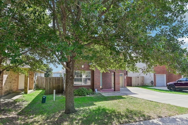 obstructed view of property featuring a garage and a front lawn