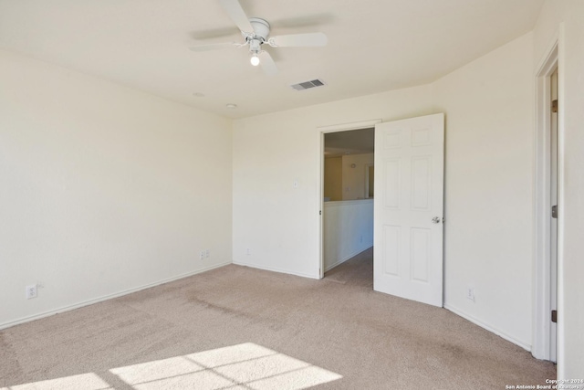 carpeted spare room featuring ceiling fan