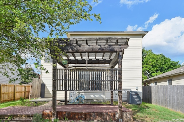 rear view of property with a deck, central AC unit, and a pergola