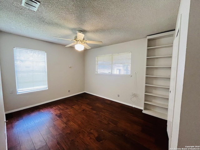 unfurnished bedroom with dark wood-type flooring, ceiling fan, and a textured ceiling