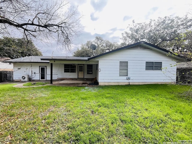 back of house featuring a patio area and a lawn