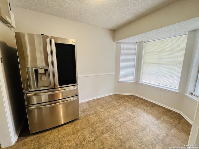 kitchen with a textured ceiling and stainless steel fridge