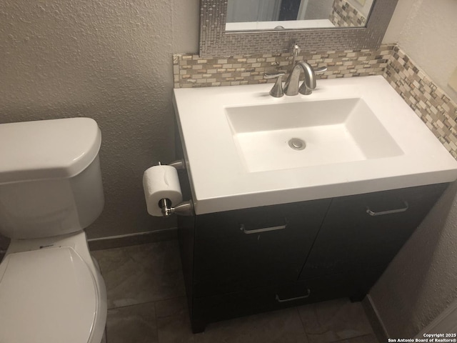 bathroom with toilet, tasteful backsplash, and vanity