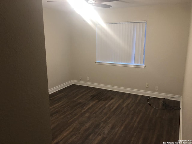 empty room featuring ceiling fan and dark wood-type flooring