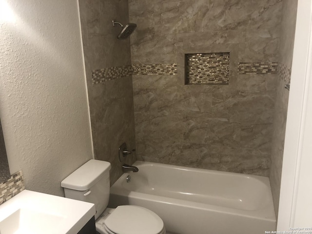 full bathroom with toilet, vanity, and tiled shower / bath