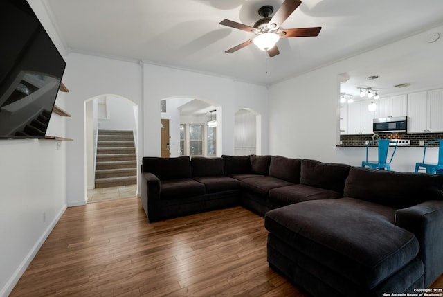 living room featuring ceiling fan, hardwood / wood-style floors, and crown molding