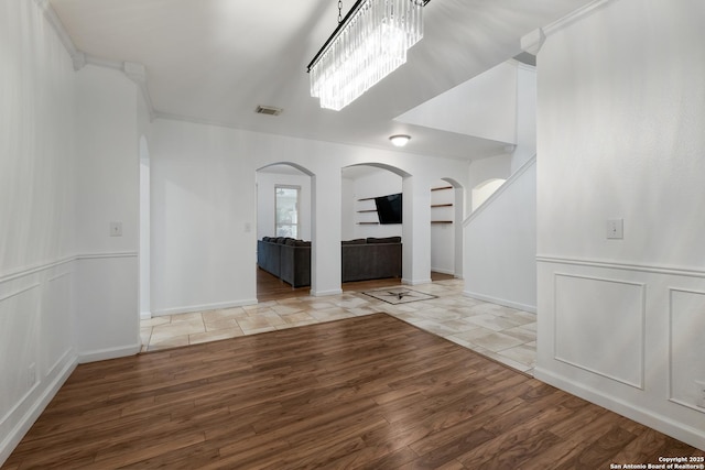 unfurnished living room with ornamental molding and light hardwood / wood-style flooring