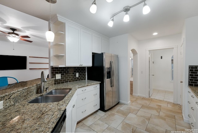 kitchen featuring white cabinets, decorative light fixtures, stainless steel appliances, sink, and backsplash