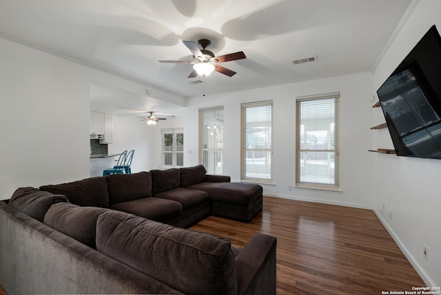 living room featuring ceiling fan, dark wood-type flooring, and ornamental molding