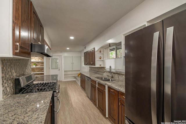 kitchen with light stone counters, sink, appliances with stainless steel finishes, and extractor fan