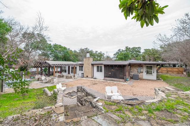 rear view of property with central AC, a pergola, a patio area, and a sunroom