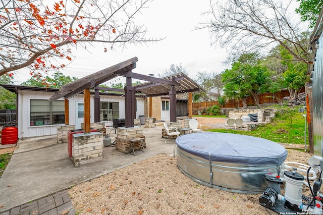 view of patio with a hot tub, a pergola, and an outdoor fire pit