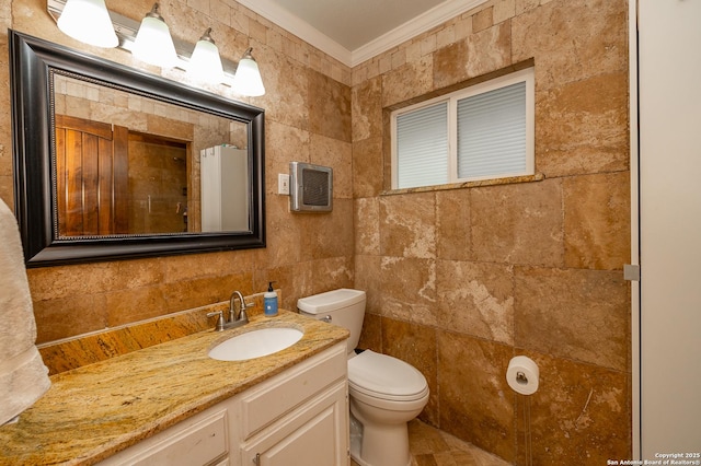 bathroom with toilet, vanity, tile walls, and ornamental molding