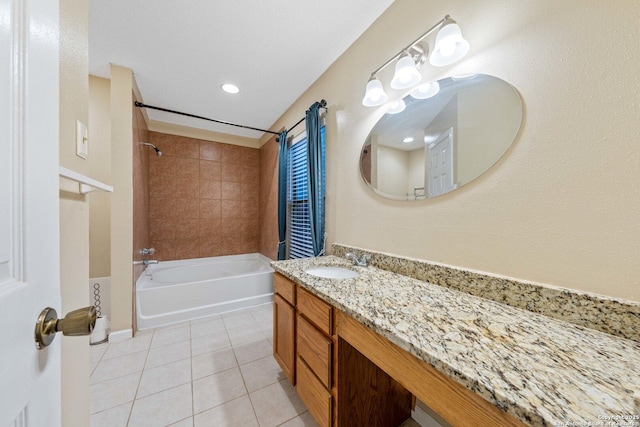 bathroom with tiled shower / bath combo, tile patterned floors, and vanity