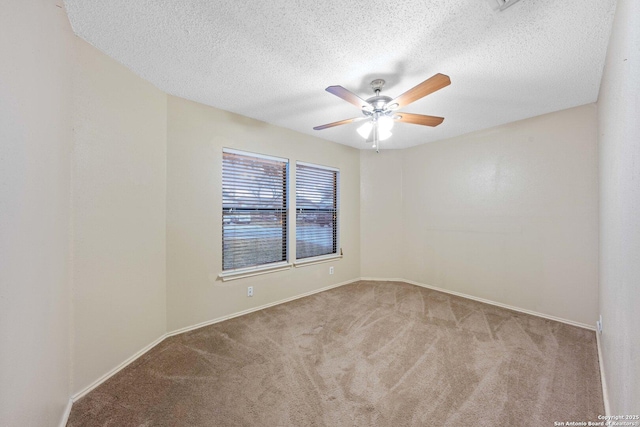 spare room featuring light carpet, ceiling fan, and a textured ceiling