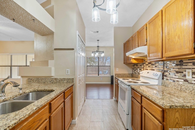 kitchen featuring white electric range, sink, hanging light fixtures, backsplash, and light stone counters