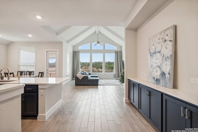 kitchen with decorative light fixtures, sink, lofted ceiling with beams, and ceiling fan