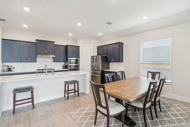 dining area featuring light wood-type flooring and sink