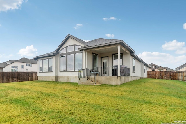 rear view of house featuring a lawn