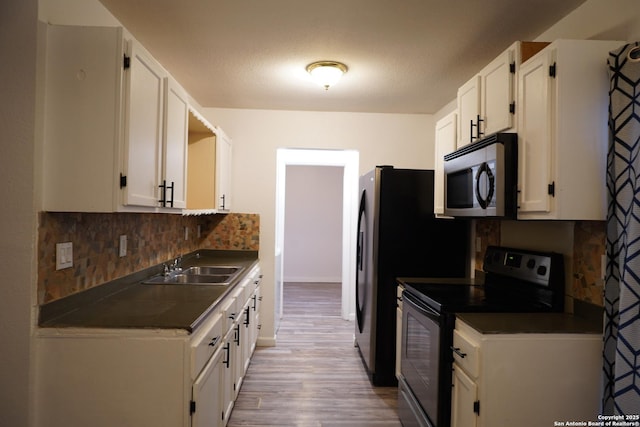 kitchen with sink, white cabinets, range with electric cooktop, and tasteful backsplash