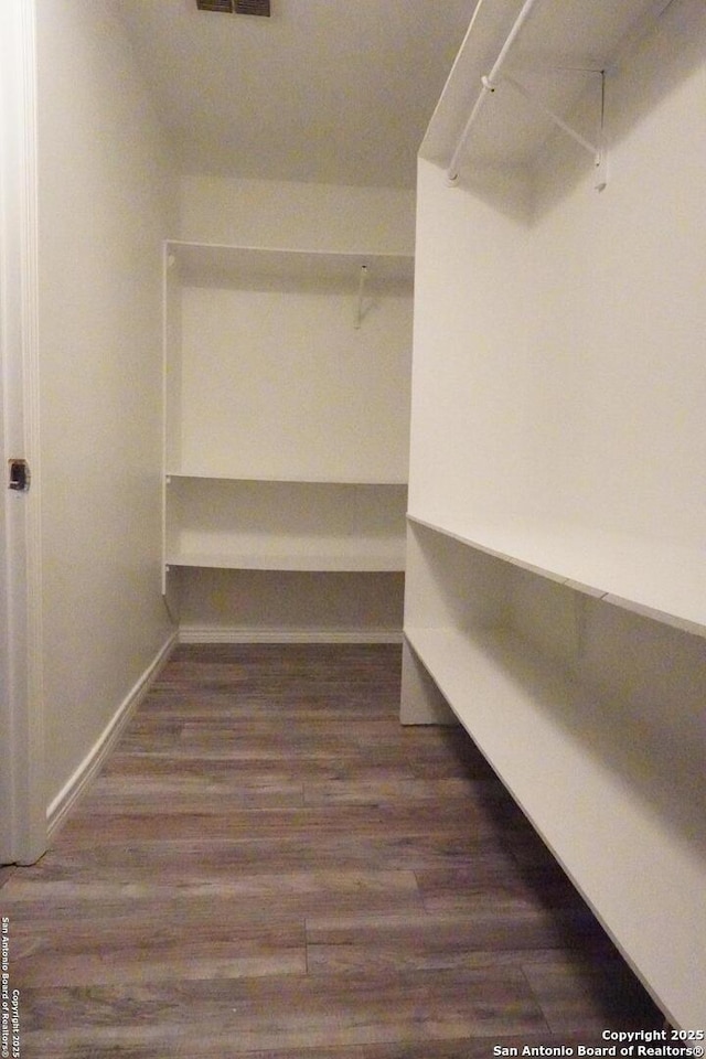 spacious closet with dark hardwood / wood-style floors