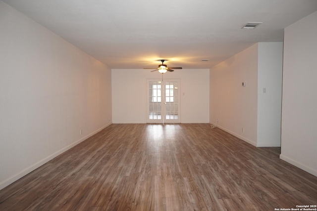 spare room with ceiling fan, french doors, and dark wood-type flooring