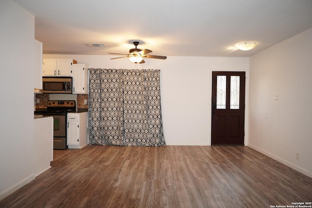 interior space with ceiling fan, backsplash, dark hardwood / wood-style floors, white cabinetry, and stainless steel appliances