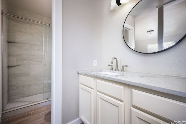 bathroom featuring a shower with door, hardwood / wood-style floors, and vanity