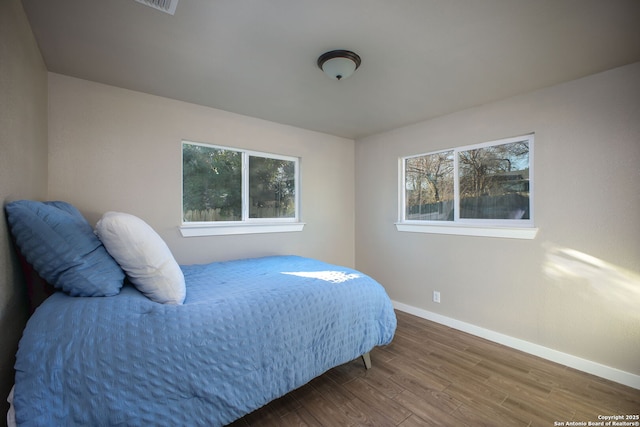 bedroom featuring multiple windows and hardwood / wood-style floors