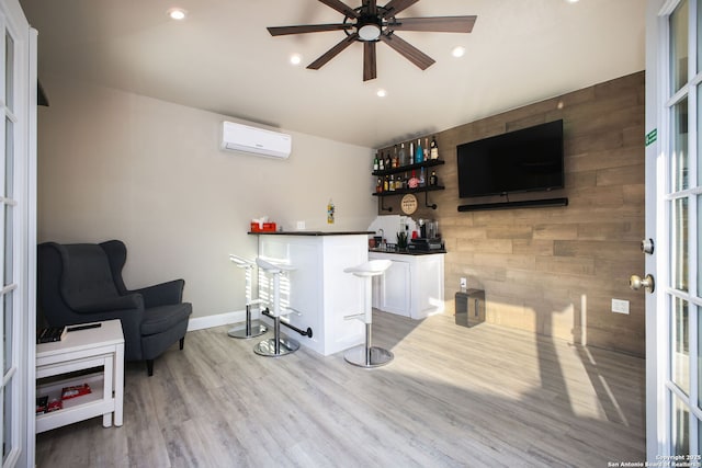 bar with white cabinetry, wood walls, hardwood / wood-style floors, a wall unit AC, and french doors