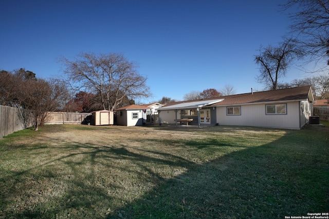 back of property with a lawn, central AC, a storage unit, and a patio