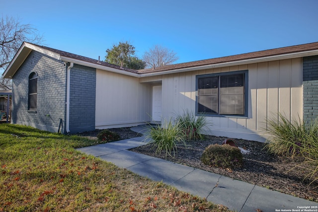 view of exterior entry with a yard