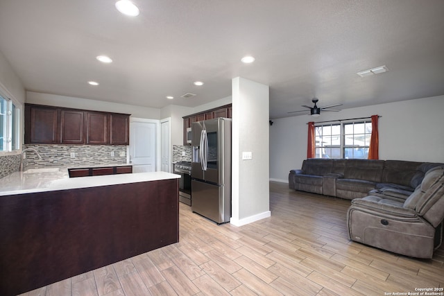 kitchen featuring backsplash, dark brown cabinets, sink, and stainless steel appliances