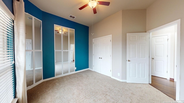 unfurnished bedroom with ceiling fan, multiple closets, and carpet floors