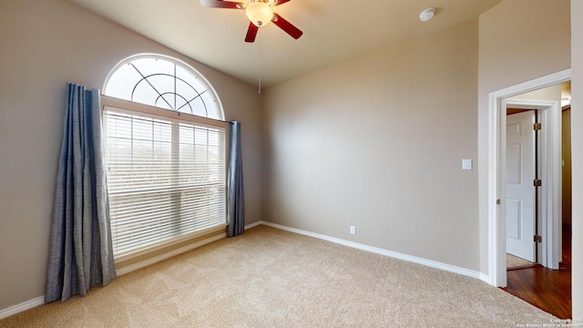 carpeted spare room featuring ceiling fan and lofted ceiling