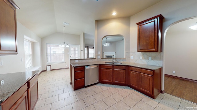 kitchen featuring dishwasher, lofted ceiling, sink, backsplash, and light tile patterned floors