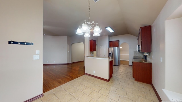 kitchen featuring vaulted ceiling, stainless steel appliances, tasteful backsplash, an inviting chandelier, and light tile patterned flooring