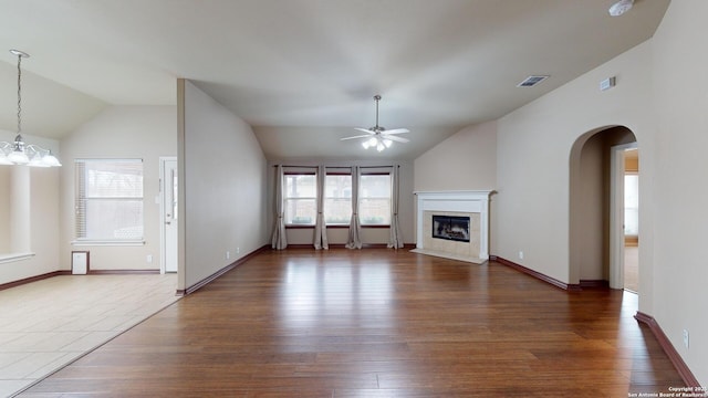 unfurnished living room with ceiling fan, dark wood-type flooring, and lofted ceiling