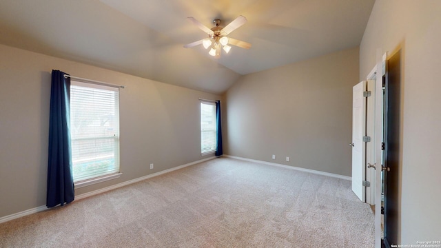 carpeted spare room featuring ceiling fan and lofted ceiling